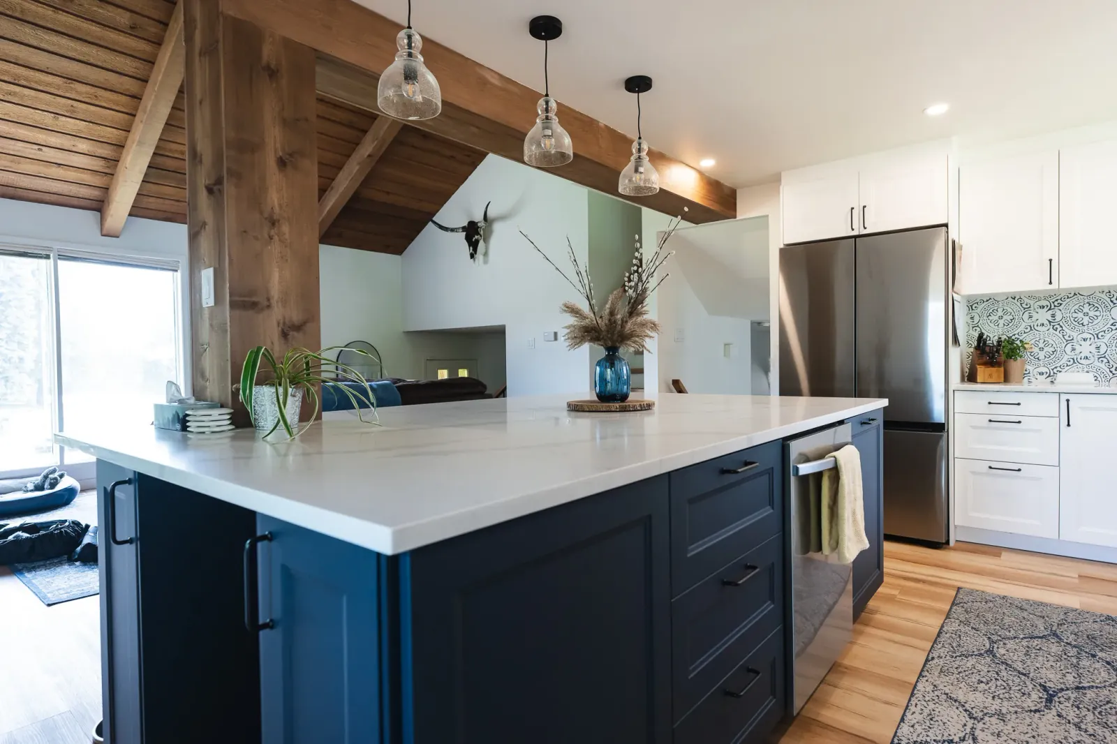 Kitchen island with matte blue doors and an elegant white quartz countertop with a custom built-in a Calgary kitchen reno