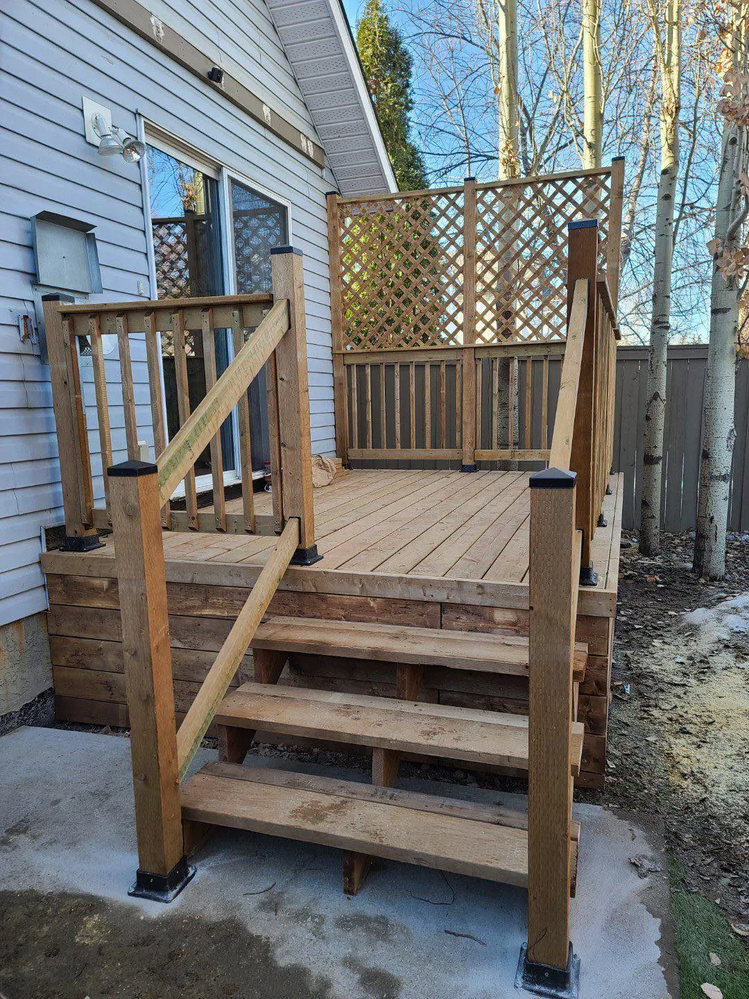 Pressure treated Deck with stairs and handrail in an exterior Calgary Reno