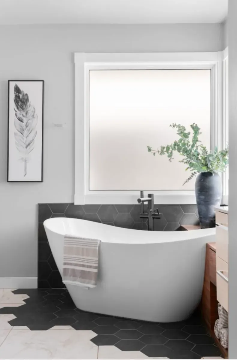 Modern freestanding bathtub in Calgary bathroom renovation with tiled accent wall