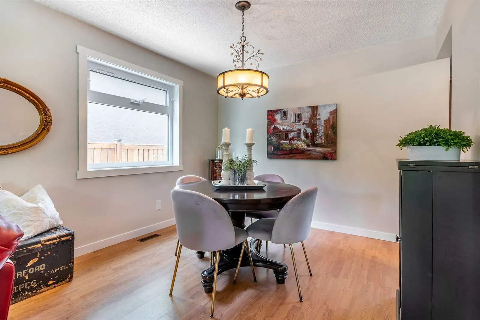 Cozy dining room with a round solid wood four piece dining table set in a man floor renovation