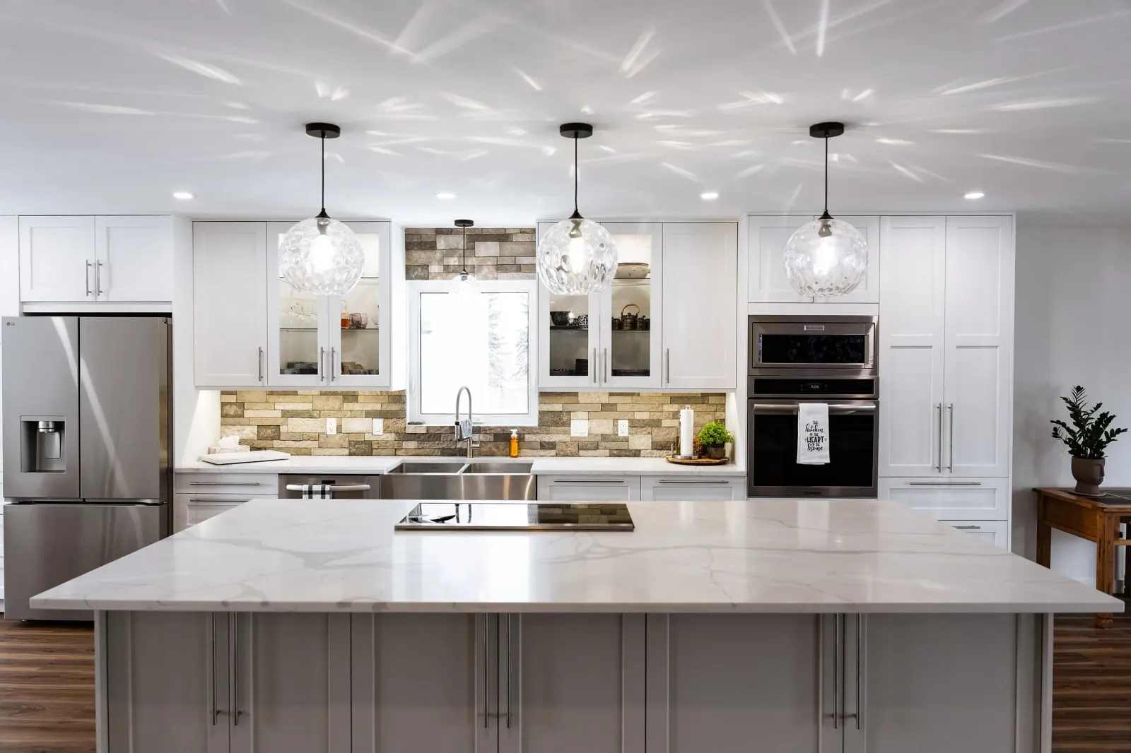 Simple, modern and elegant kitchen island with three amazing pendants in a home renovation